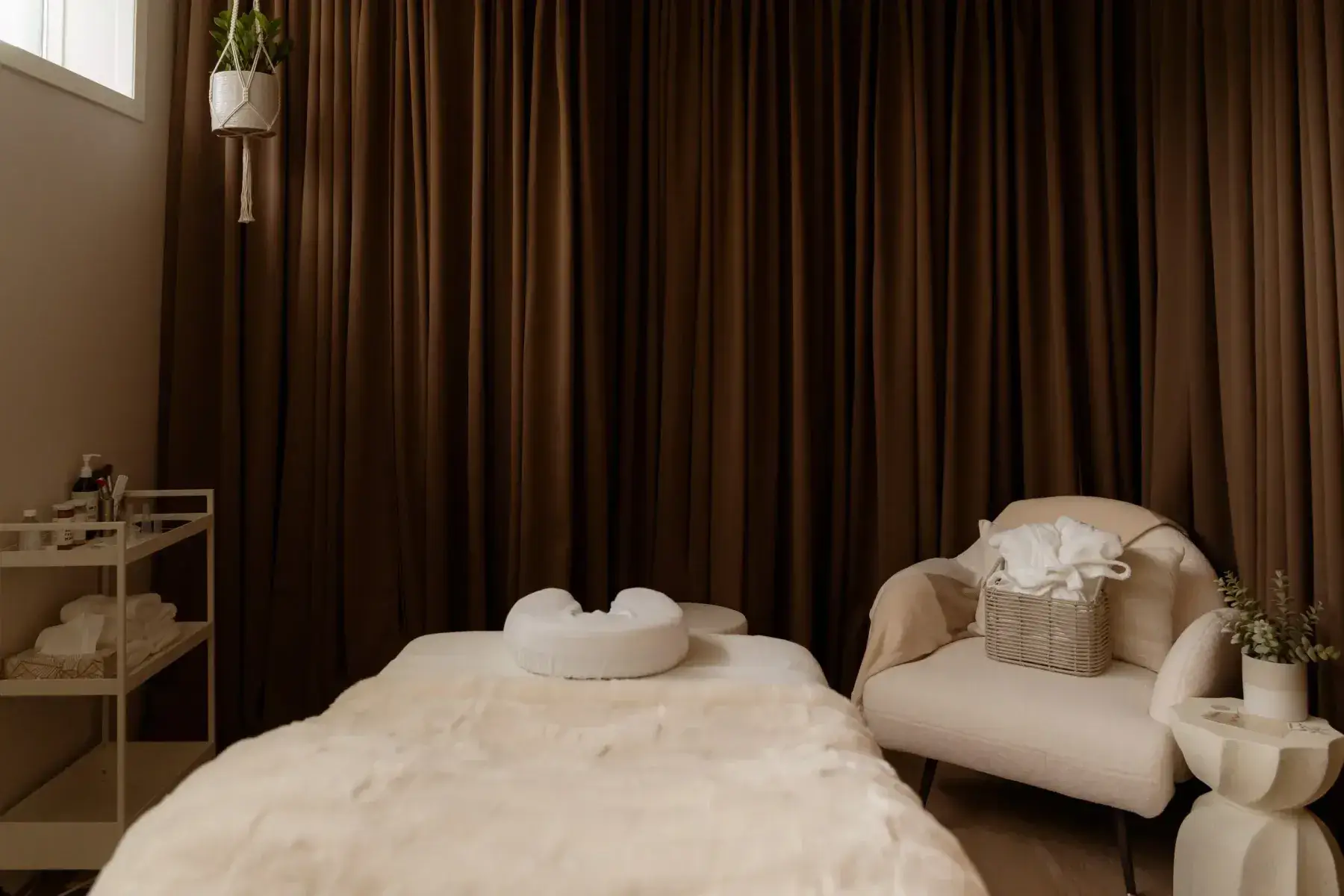 A treatment room at Renu with linen curtains and low, warm light